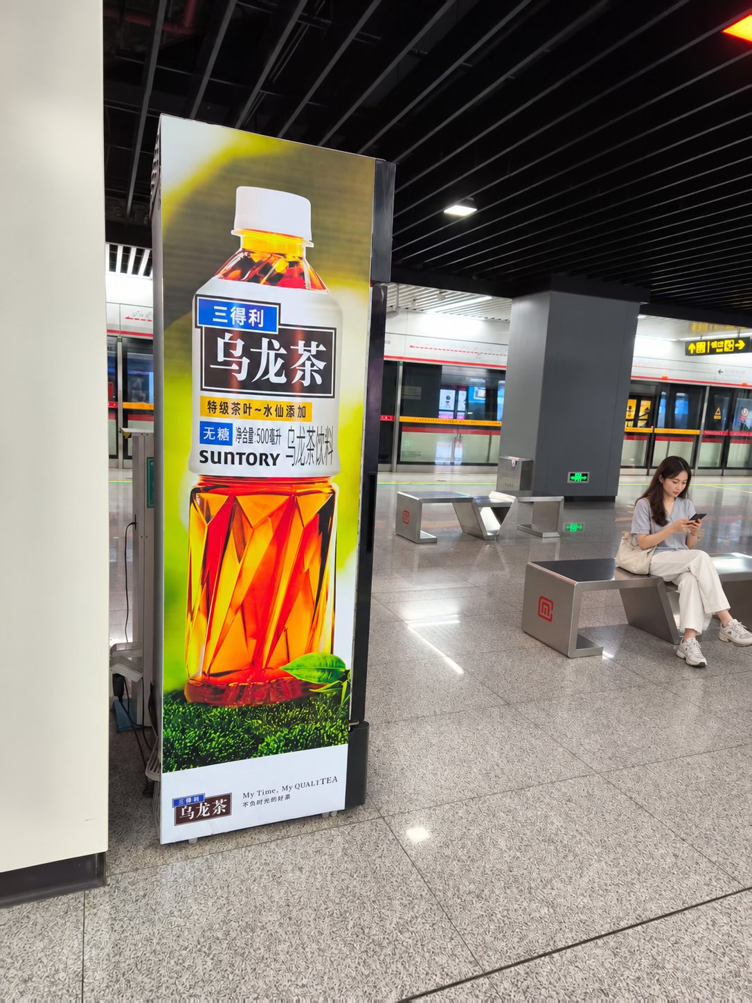 常州地铁某站站台的一台立式广告柜机，画面为三得利乌龙茶